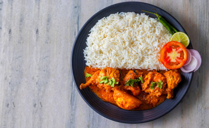 A Dish of rice and  chicken grevy with onion